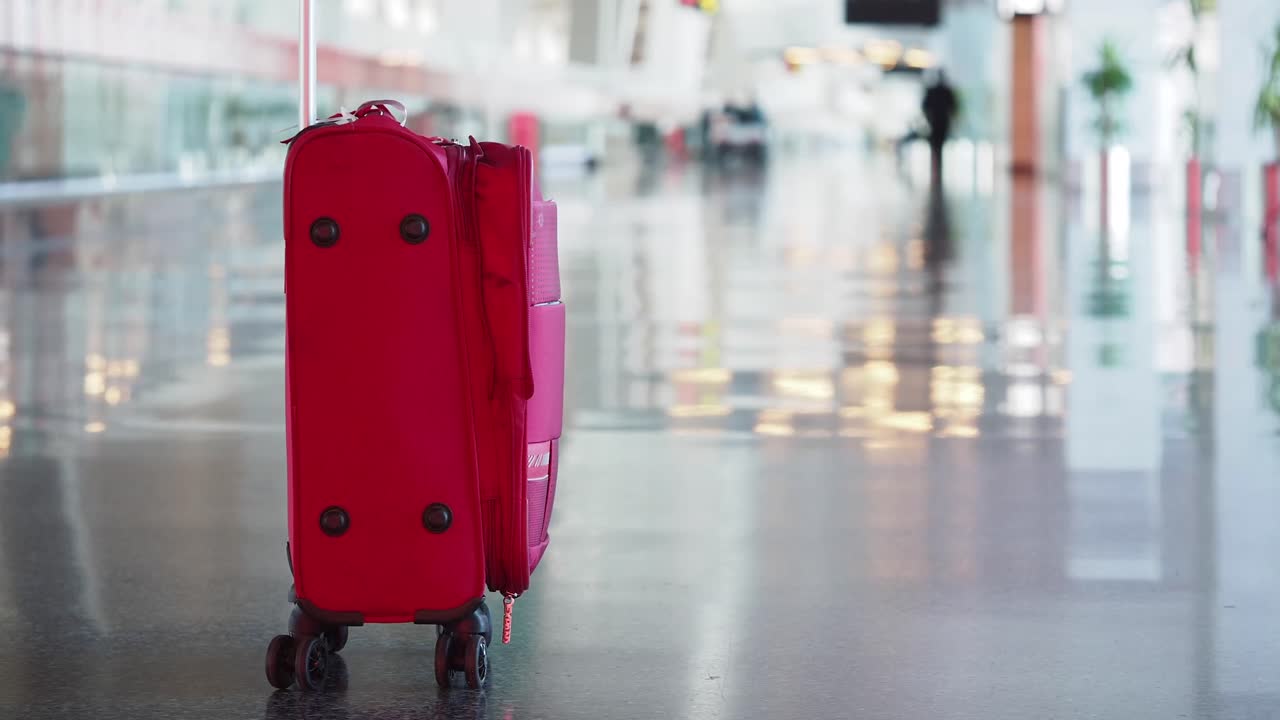 Red Suitcase in Airport Terminal