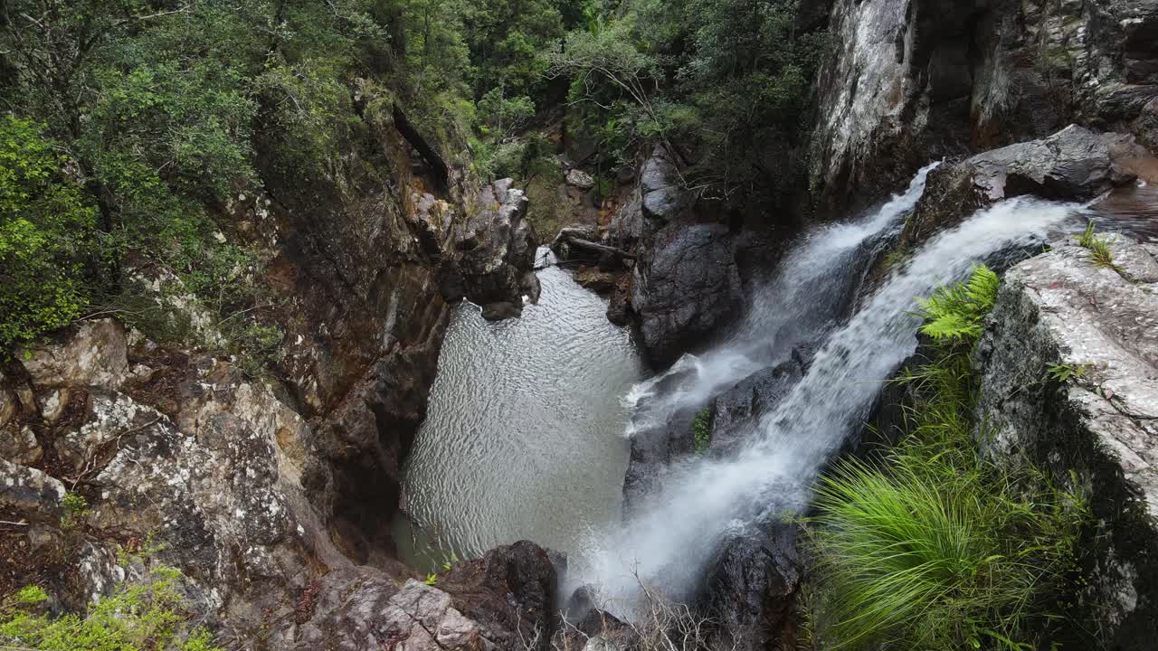 cascadas gemelas que caen en cascada desde una antigua selva tropical hasta una formación rocosa natural para nadar.