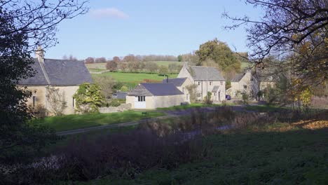 panning view of some quaint cottages in the historic cotswolds village of upper slaughter