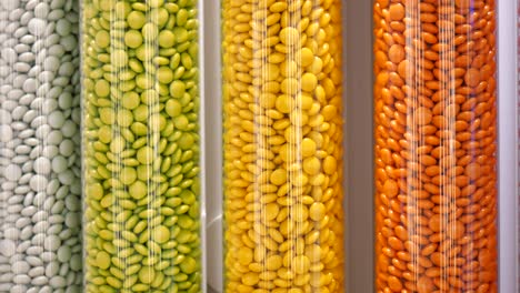 dulces de colores en recipientes cilíndricos