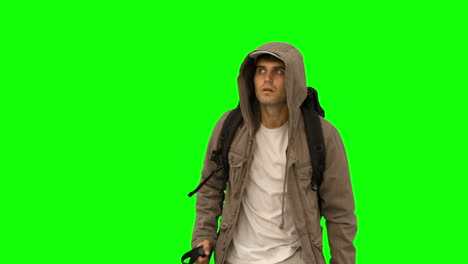 Attractive-man-with-a-coat-trekking-on-green-screen