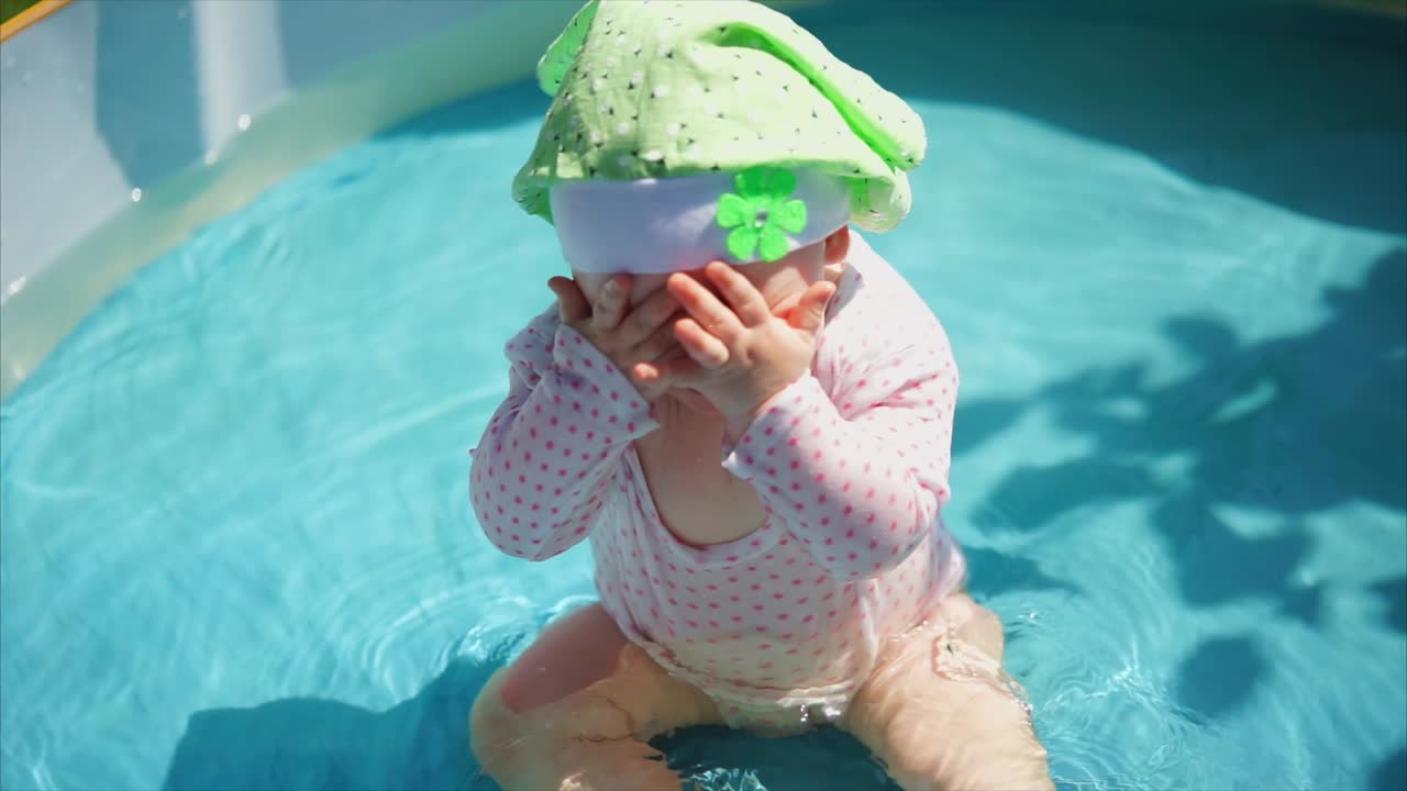 Baby girl playing in a kiddie pool