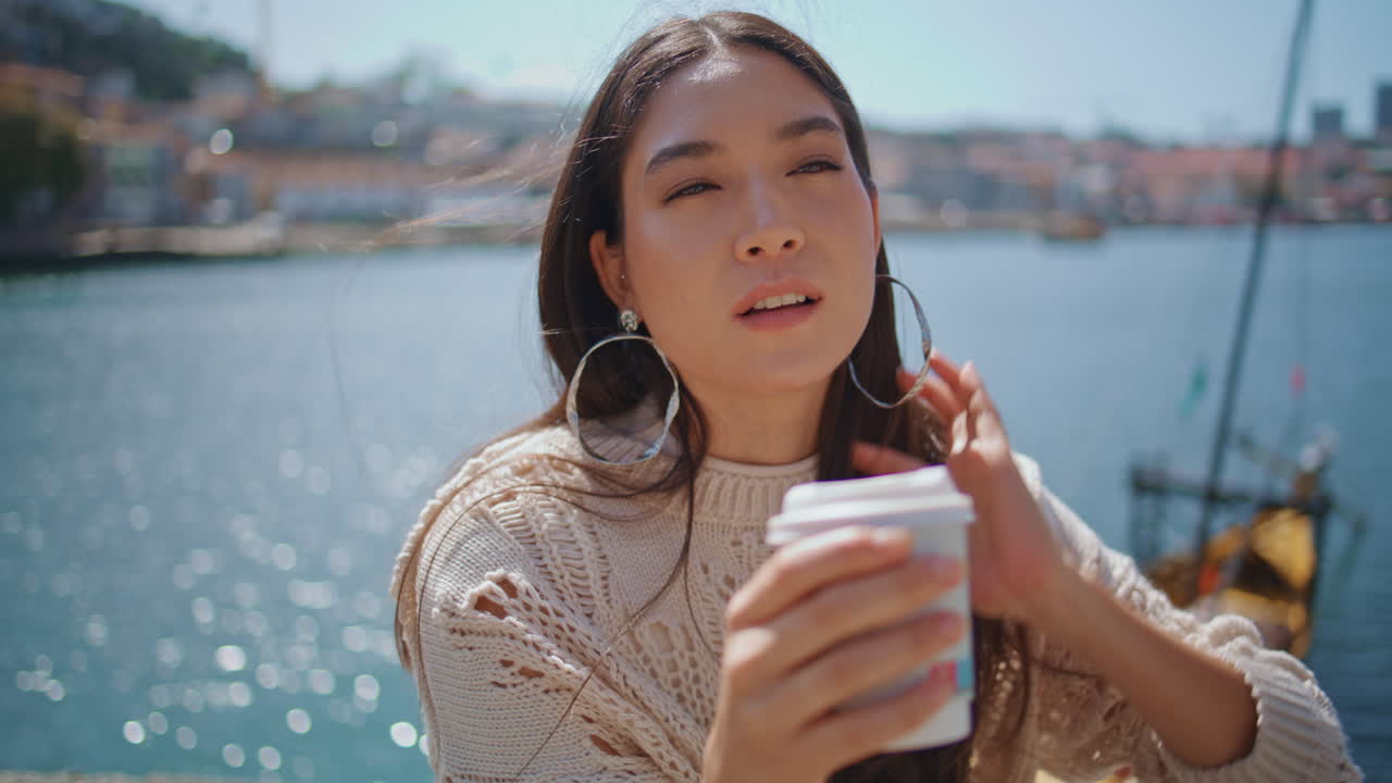Windy hair woman relaxing in sunny river bank closeup. Happy girl posing camera