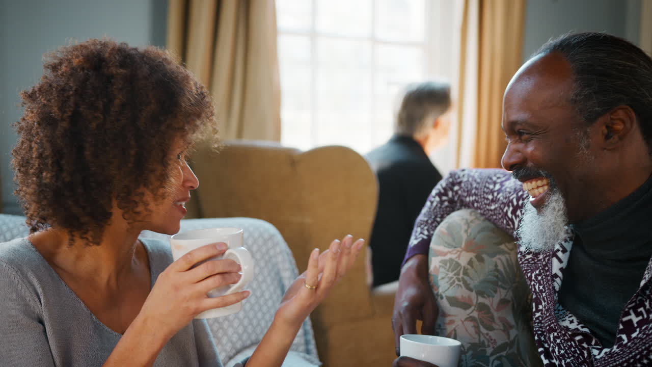 Middle Aged Couple Sitting Around Table In Coffee Shop