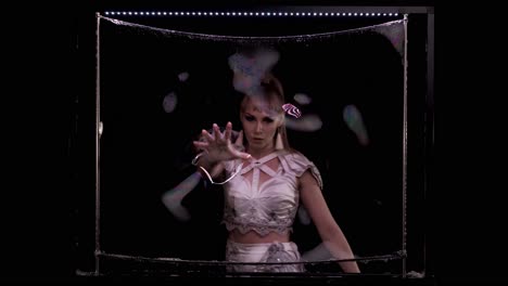 girl does tricks with soap bubbles she plays her hand on soap screen on vertical frame with led light