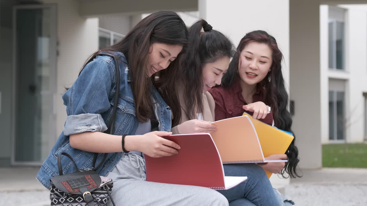 three asian girl students talking at break time sitting on campus