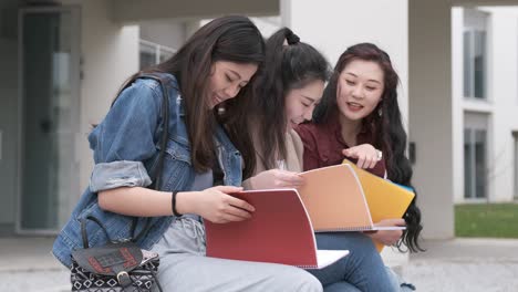 three asian girl students talking at break time sitting on campus