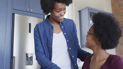 Glückliche-Afroamerikanische-Mutter-Und-Tochter,-Die-Gemeinsam-Hausaufgaben-In-Der-Küche-Machen