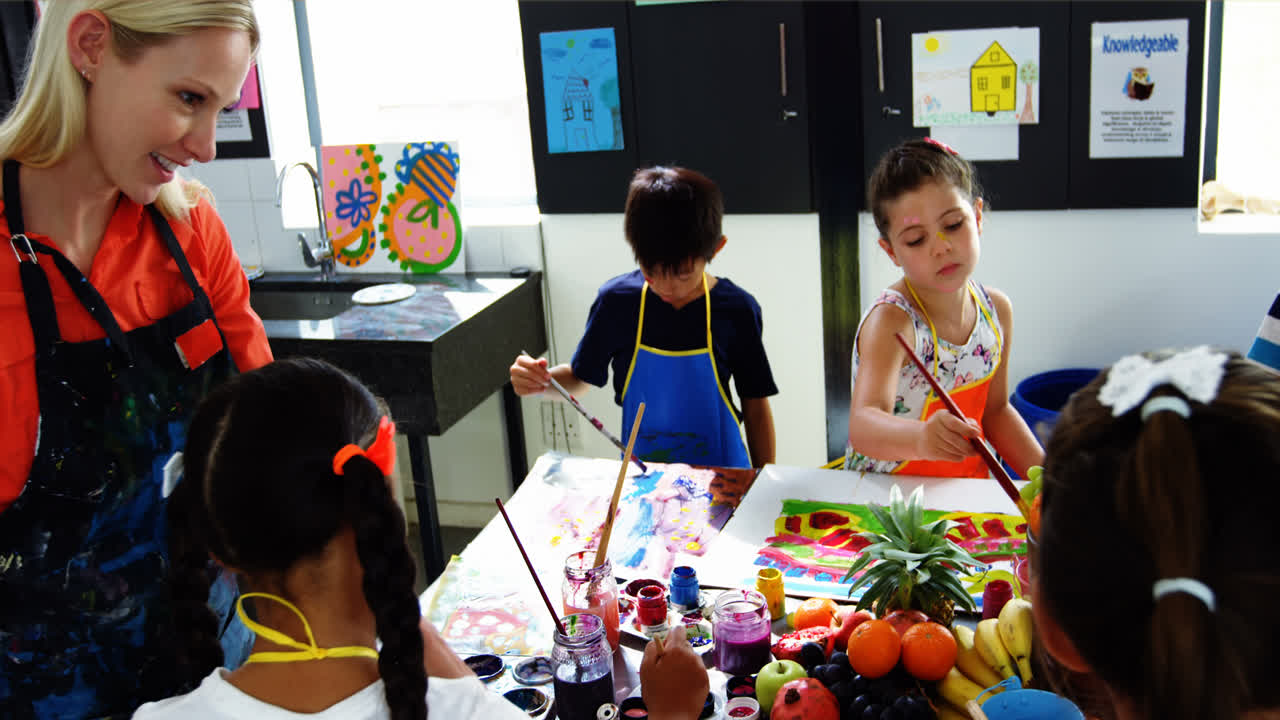 그림 을 그리는 수업 에서 학생 들 을 도와 주는 교사