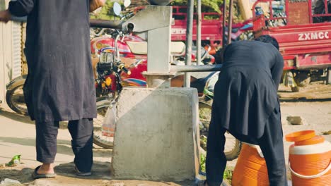 Men-Wearing-Traditional-Cloths-Using-A-Water-Pump