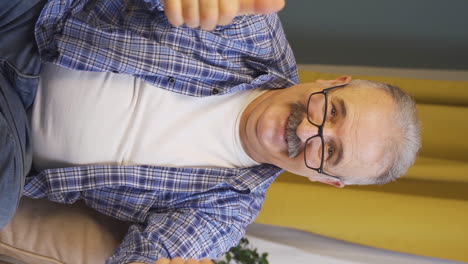 Vertical-video-of-Old-man-making-heart-sign-at-camera.