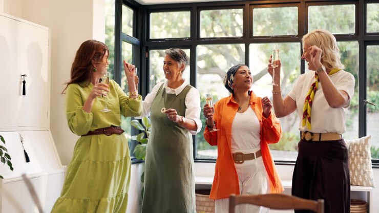 Un gruppo di donne festeggia in un ambiente chiuso con champagne