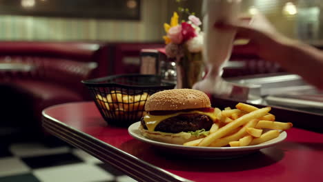 a classic diner meal featuring a burger, fries, and milkshake