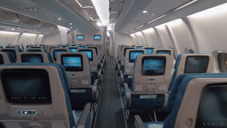 airplane cabin with aisle and empty seats of economy class