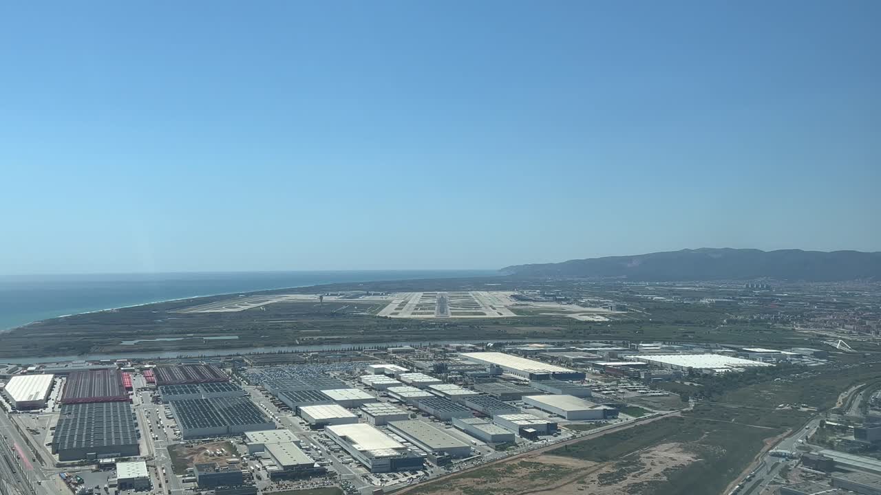 perspectiva de piloto inmersiva del aeropuerto de barcelona en españa, filmada desde un avión que se acerca al aeropuerto