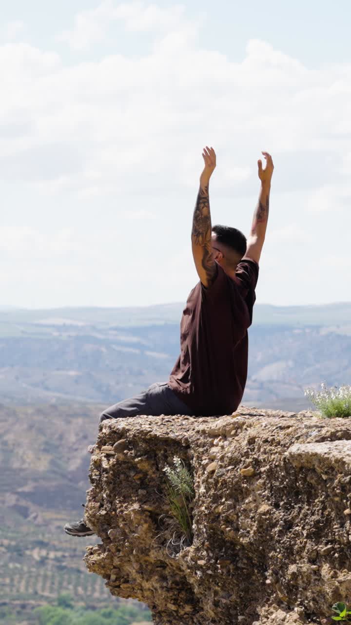 Man taking a photo from cliff edge in gorafe, spain. Vertical