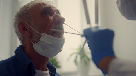 closeup senior patient giving test rapid coronavirus antigen in modern clinic.