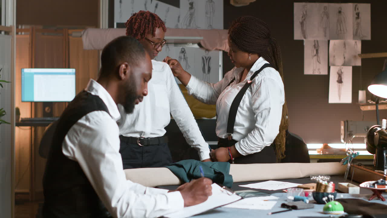 재단사를 위해 포즈를 취하는 고객