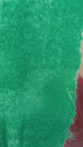 cu, dolly shot: beautiful young woman paints wall with green color near hugging boyfriend at room construction closeup