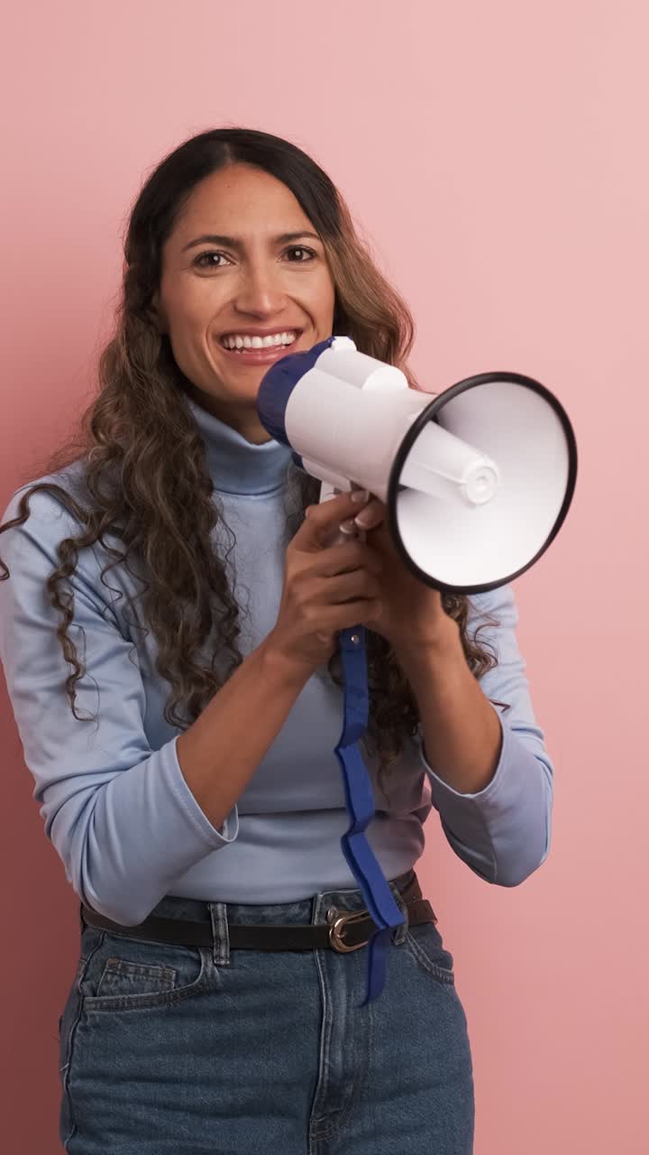 Colombian woman using a loudspeaker and yelling positive. Vertical footage