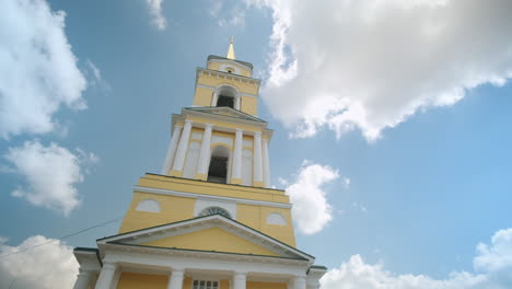 yellow church tower against a cloudy sky