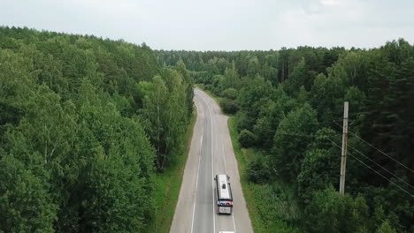 bus on a country road through a forest