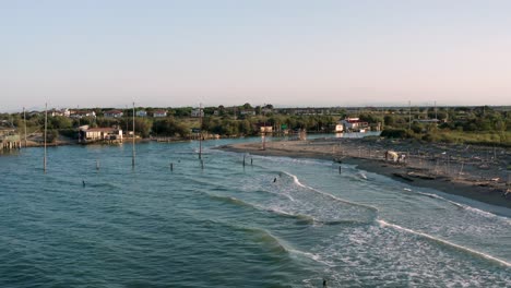 Vista-Aérea-De-Las-Cabañas-De-Pesca-Con-La-Típica-Máquina-De-Pesca-Italiana,-Llamada-&quot;trabucco&quot;,lido-Di-Dante,-Fiumi-Uniti-Ravenna-Cerca-Del-Valle-De-Comacchio