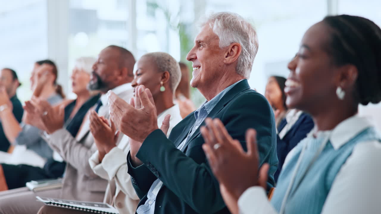 Persone d'affari sorridenti che applaudono durante una presentazione a una conferenza