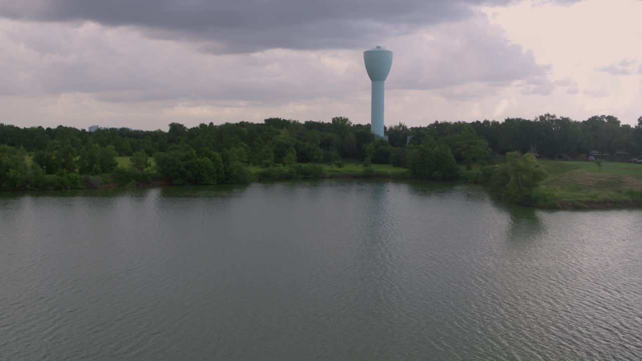 Hellblauer Wasserturm und Brays Bayou, der durch Alief, Houston, verläuft – Drohnenansicht