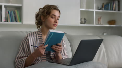 Primer-Plano-Joven-Empresaria-Tomando-Notas-Viendo-Conferencias-En-Línea-En-Casa.