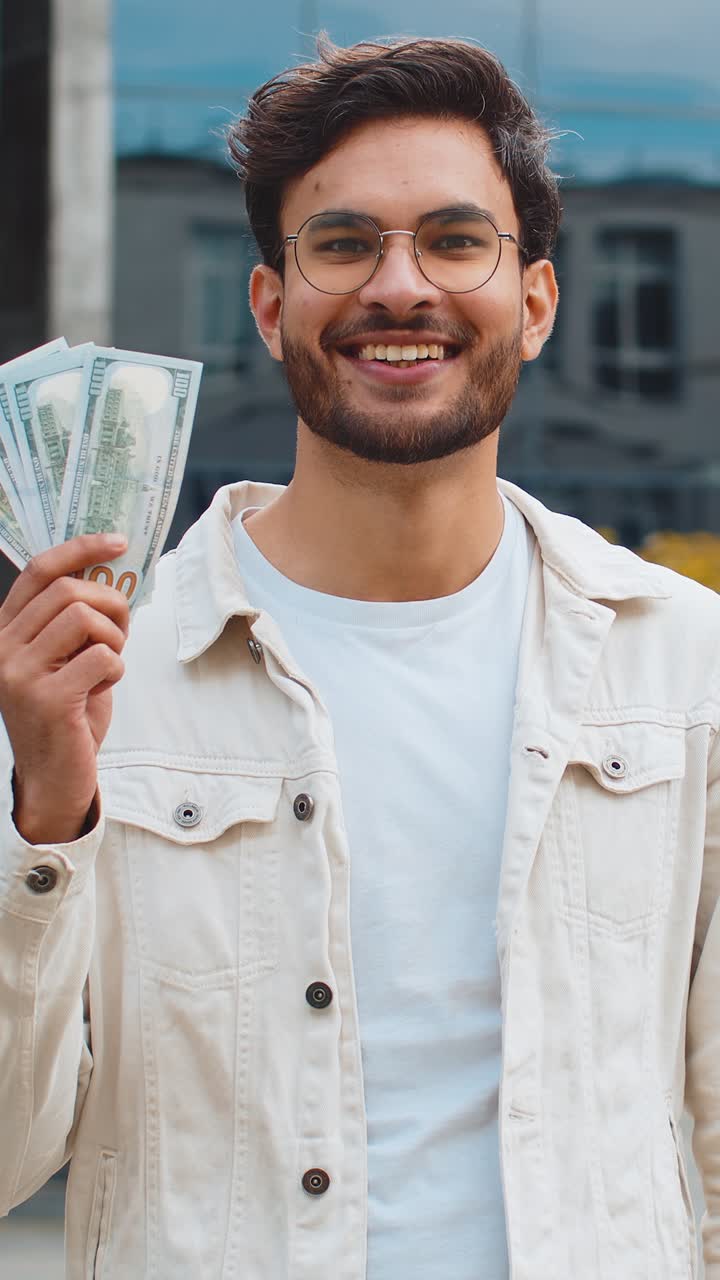 Happy successful rich indian man counting money cash dollars salary profit reward bribe jackpot