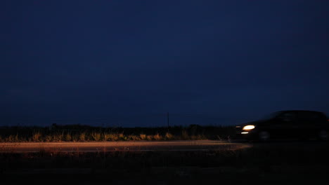 black car driving on a country road at twilight
