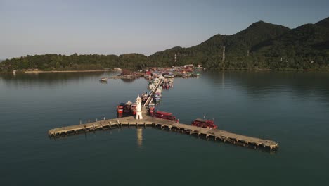 Slow-aerial-shot-above-Bang-Bao-pier-along-the-coast-of-Koh-Chang,-Thailand