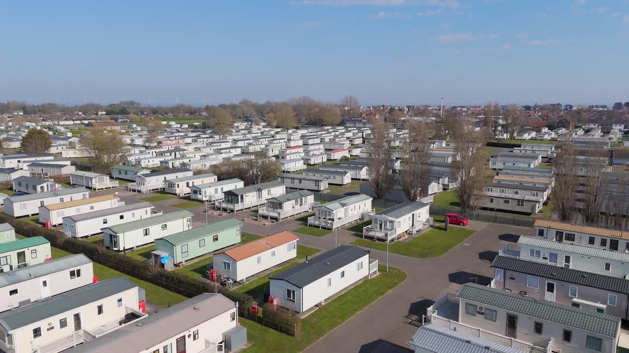 Warm light bathing the coastal holiday town of Skegness in Lincolnshire. Aerial views of hotels houses, theme parks and static holiday homes. Destination and tourist vacation, summer evening scene