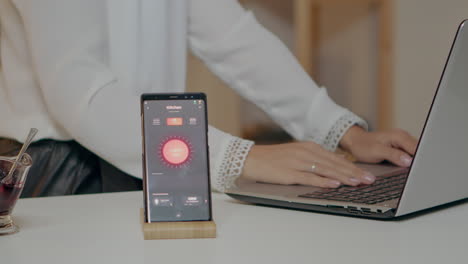 Woman-typing-at-laptop-sitting-in-home-with-automation-lighting-system