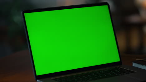 Closeup-green-screen-laptop-on-table.-Laptop-computer-with-mockup-display