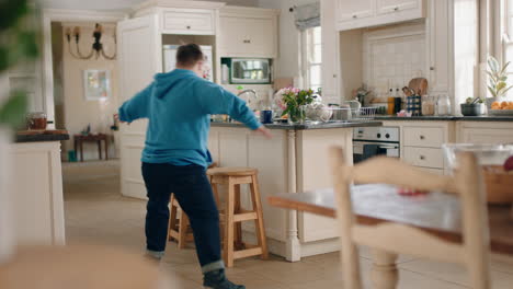 Adolescente-Feliz-Con-Síndrome-De-Down-Bailando-En-La-Cocina-Divirtiéndose-Celebrando-Un-Baile-Divertido-Disfrutando-El-Fin-De-Semana-En-Casa