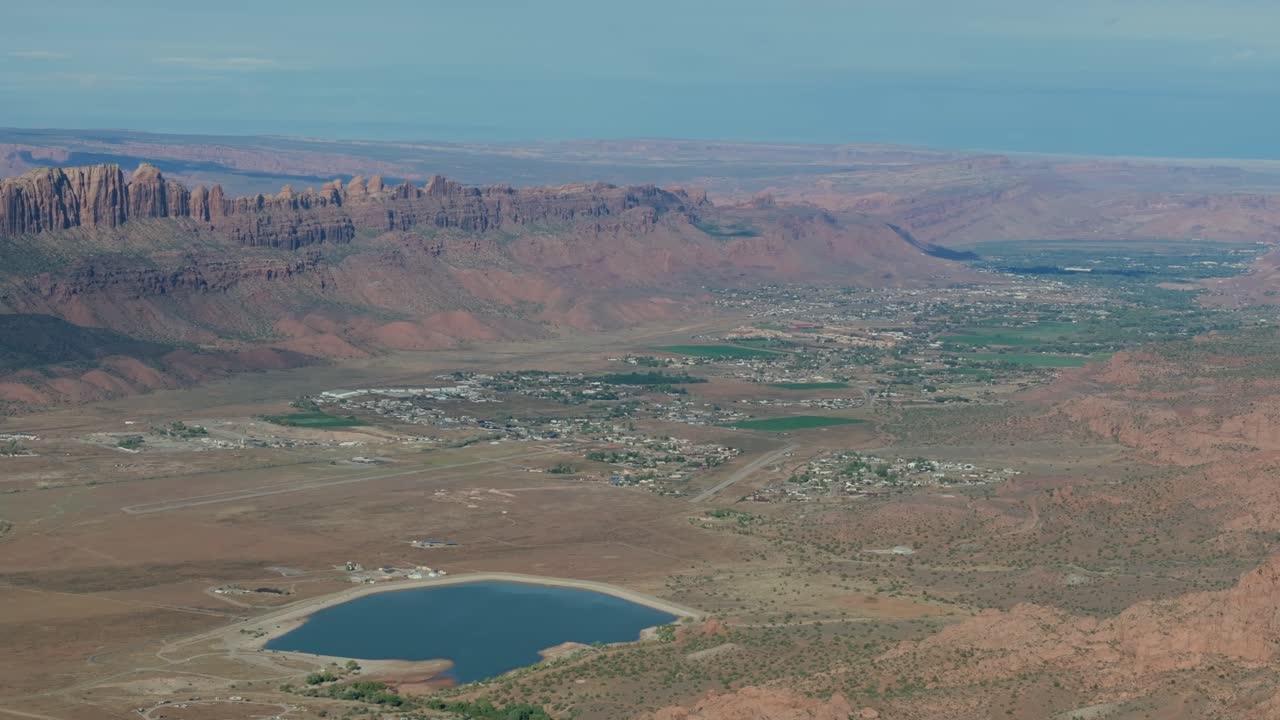 город моав с красными скальными образованиями, пустыня, небольшой город и живописное озеро, вид с воздуха