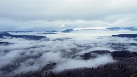 Aerial-view-of-low-clouds-with-emerging-mountains