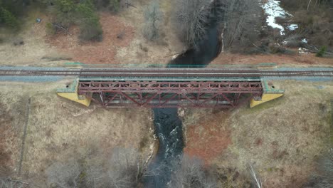 aerial: old metal bridge constructed over flowing river in eastern europe