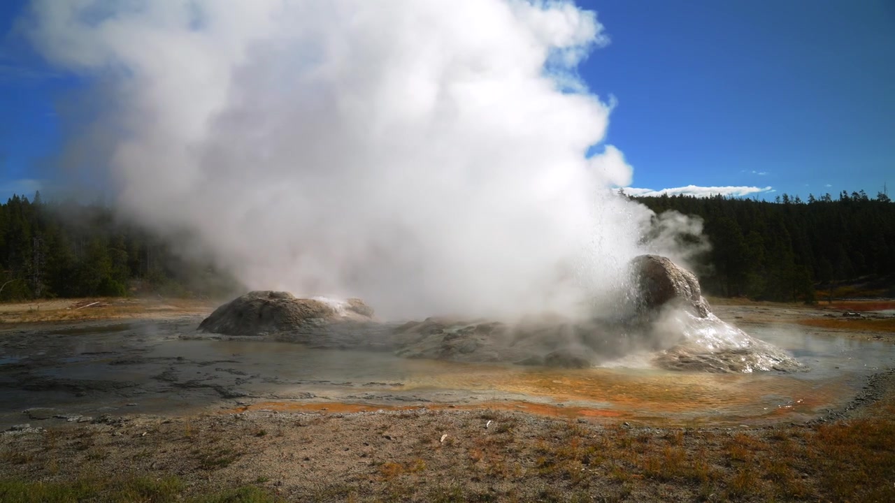 Wyoming'deki Yellowstone Milli Parkı'nda, Castle Gayzer, Old Faithful, Grand Gayzer ve Midway Gayzer Havzası'nın sıcak su kaynaklarından yükselen buhar. Sonbahar sabahı mavi gökyüzü ve güneşli havada Grand Prismatic Spring'in jeotermal ortamı ve doğal güzellikleri.