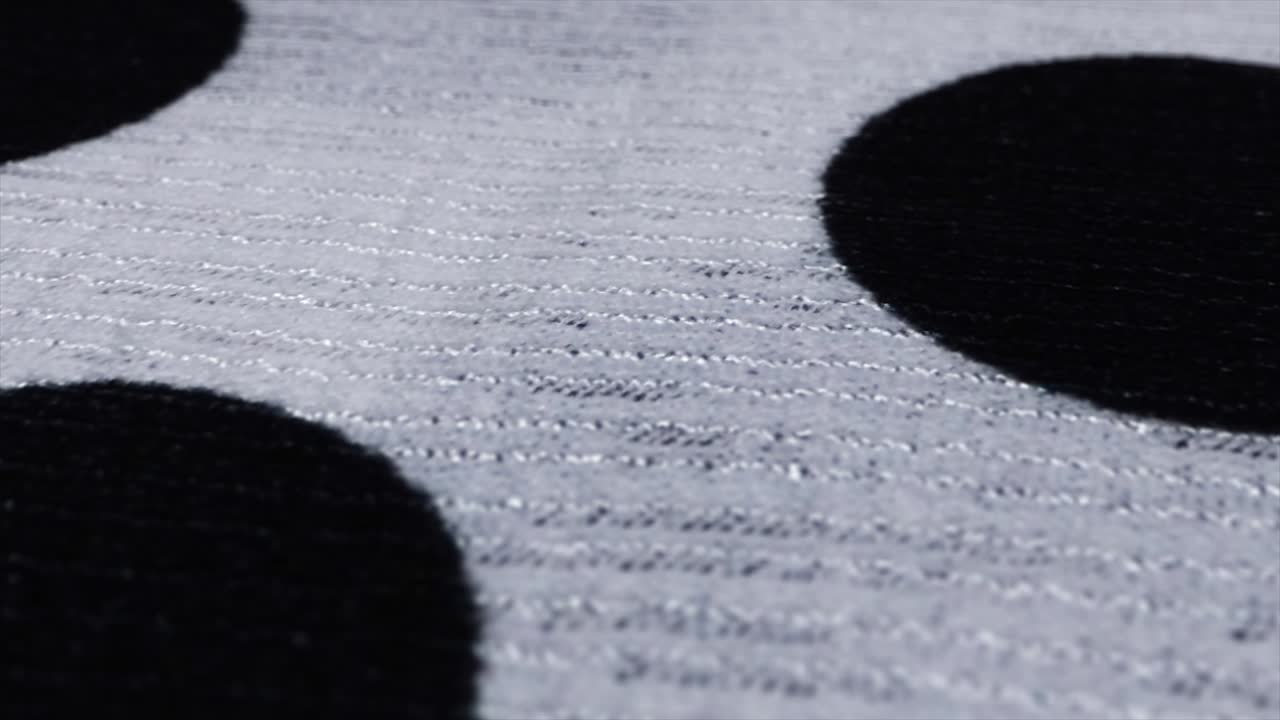 tela de tela manchada disparada de cerca. puntos negros sobre fondo blanco, patrón monocromático.