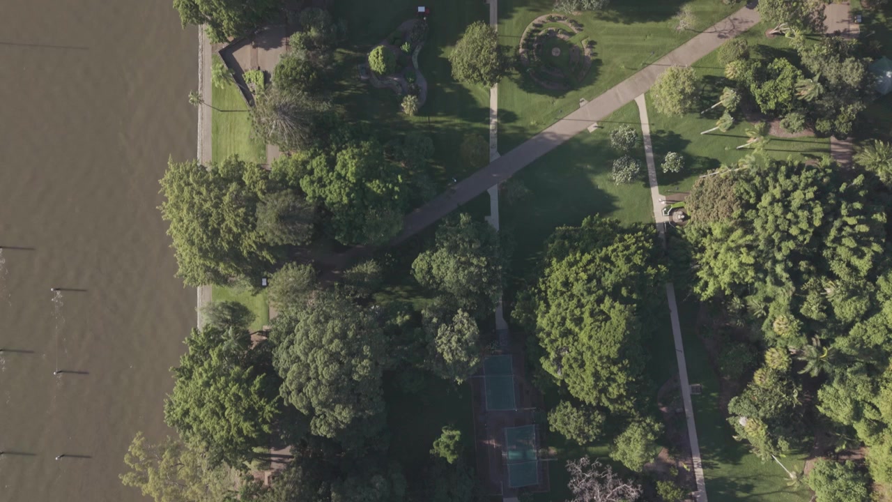 An aerial view shows garden paths crossing manicured lawns and trees in Brisbane Botanic Gardens.