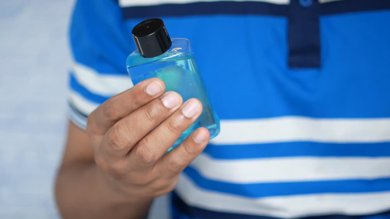 persona con una botella de desinfectante para manos