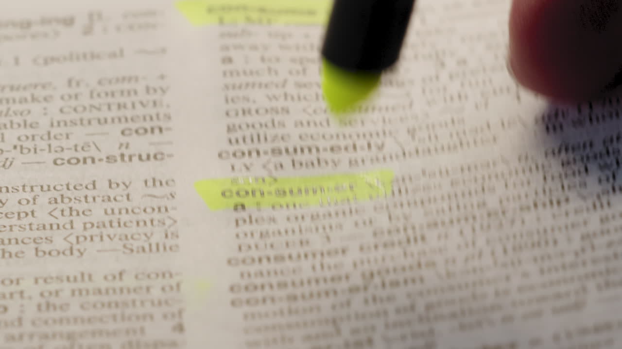 Consumer Economic Dictionary Highlighter Concept, highlighting a word in a dictionary to show it's definition