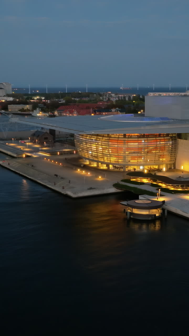 Aerial drone view of the Copenhagen Opera House in Denmark at night. Vertical