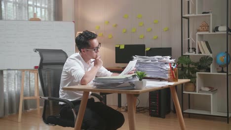 hombre asiático pensando y mirando el papel luego levantando el dedo índice mientras trabaja con documentos en la oficina