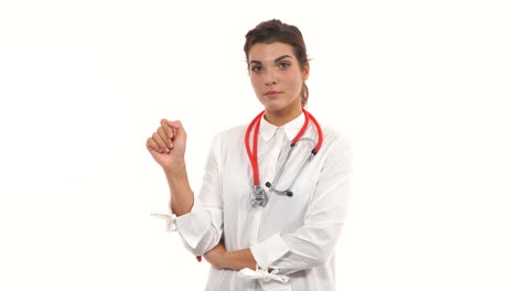 Young-female-doctor-shaking-her-finger-at-the-viewer,-warning-about-a-bad-habit.-Close-up-of-a-female-surgeon-with-stethoscope-and-lab-coat-isolated-on-white-background