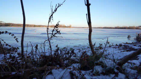 Toma-Panorámica-De-Un-Lago-Congelado-En-Invierno-Al-Atardecer