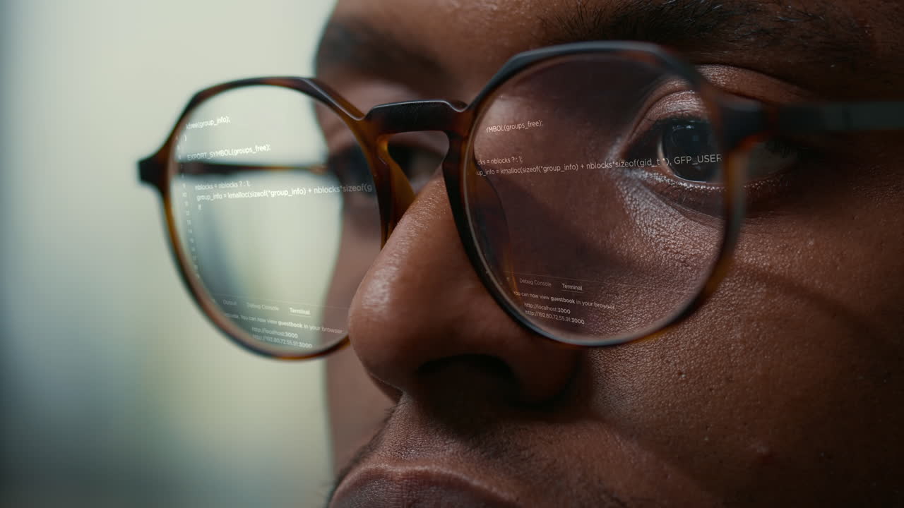 Vfx of running programming code reflected in software developer glasses